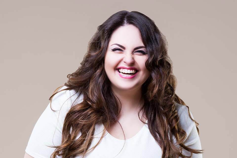 A woman with long brown hair smiling at the camera.